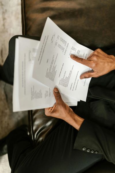 Person reviewing documents while sitting on a couch.