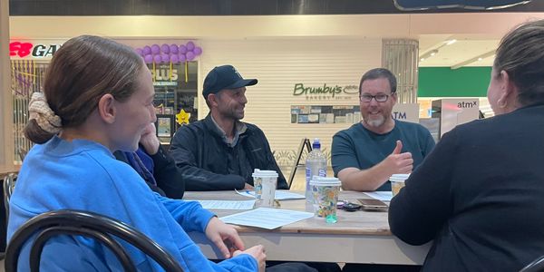 Four people gathered around a table having a discussion.