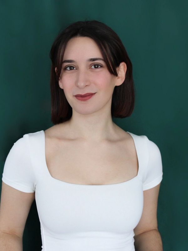 Young woman in a white top smiling.