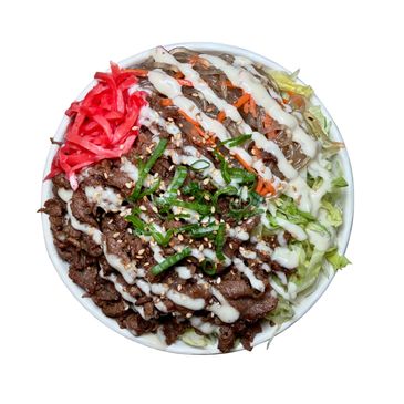 Bibimbap bowl with beef, noodles, vegetables, and creamy sauce.