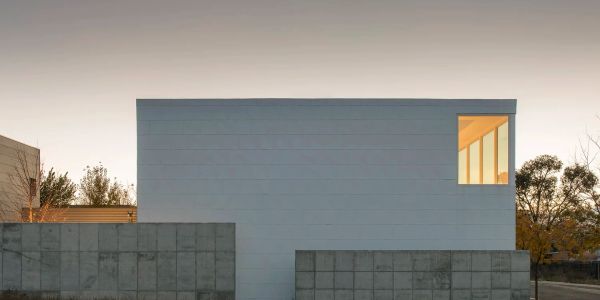 Minimalist modern house with concrete walls and a glass window.