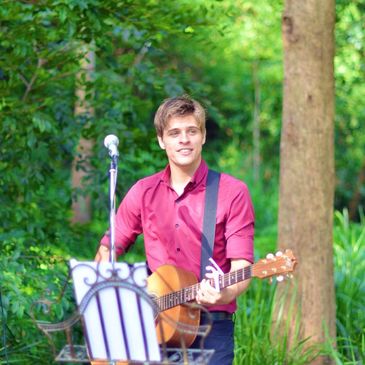 A man playing acoustic guitar at a wedding