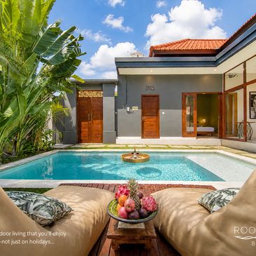 Cozy poolside lounge area with tropical plants and modern architecture.