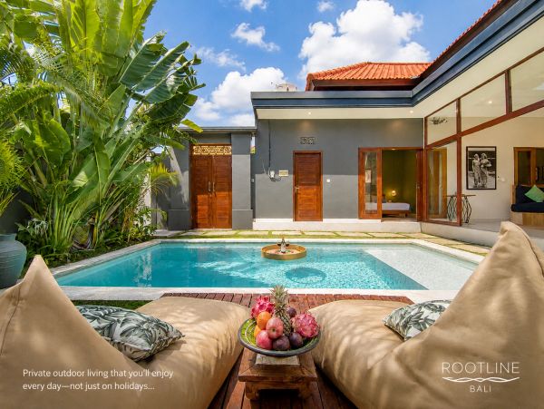 Private outdoor living space with pool and lush plants.