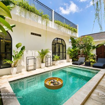 Modern outdoor pool area with tropical plants.