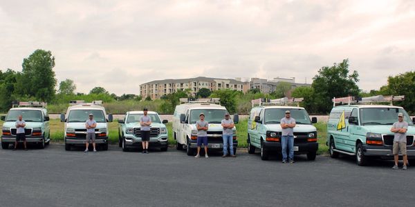 Grayzer Electric vans and employees lines up in front of a cityscape