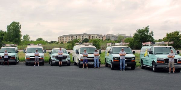 Grayzer Electric vans and employees lines up in front of a cityscape