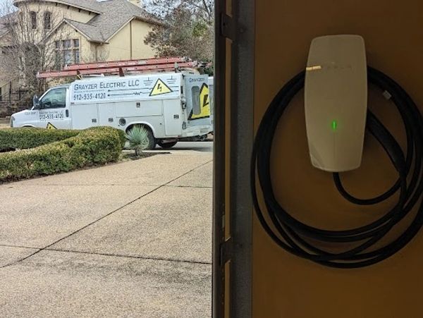 Grayzer Electric van next to a freshly installed Tesla wall connector