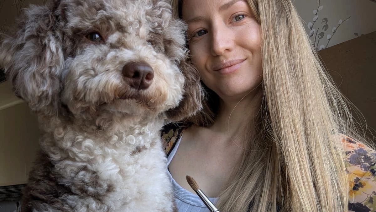 Pet portrait artist Jo Shepherd pictured with her Merle Miniature Poodle, Jasper