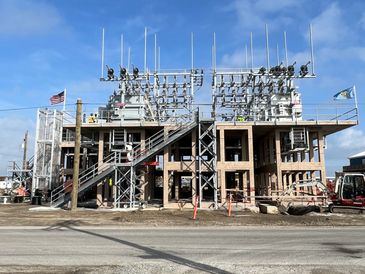 A modern electrical substation under a clear blue sky.