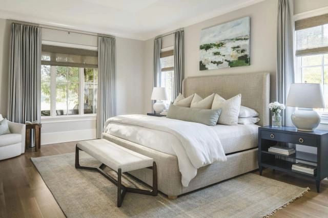 Bright and cozy bedroom with large windows and neutral tones.