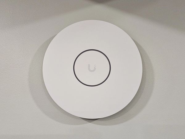 White ceiling-mounted wireless access point.