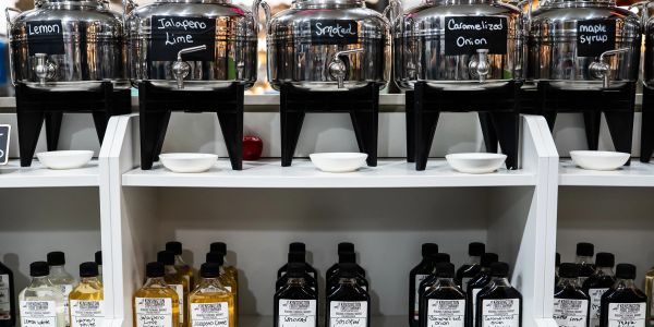 Condiment dispensers and bottles labeled with various flavors.