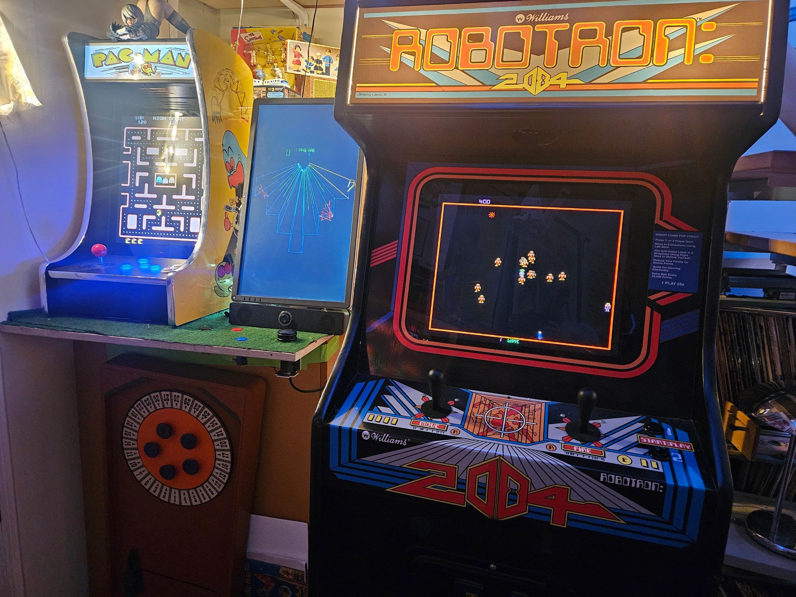 Retro arcade machines including Robotron: 2084 and Pac-Man in a cozy gaming room.