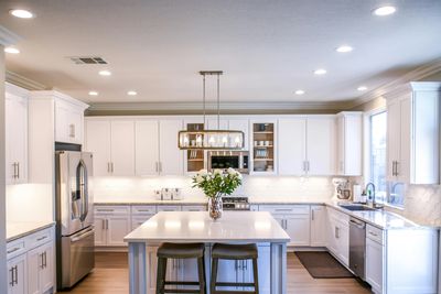 Bright modern kitchen with white cabinets and central island.