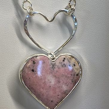 Sterling hand forged Rhodonite heart hanging on display