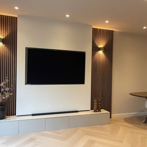 Moderne woonkamer met ingebouwde tv en minimalistische inrichting.