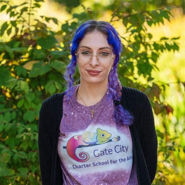 Young woman with blue-purple hair wearing a Gate City Charter School t-shirt.