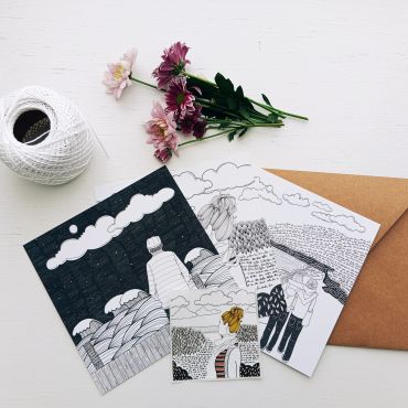 Black and white sketches with colored accents, flowers, and twine on a white surface.