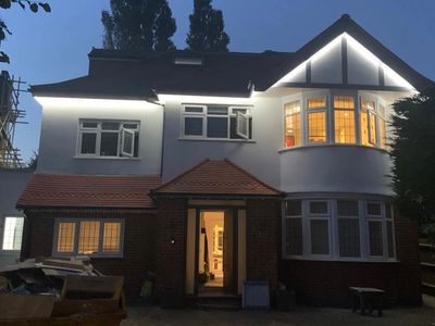A two-story house illuminated at dusk with lights inside and outside.
building services London, home renovations, property refurbishment