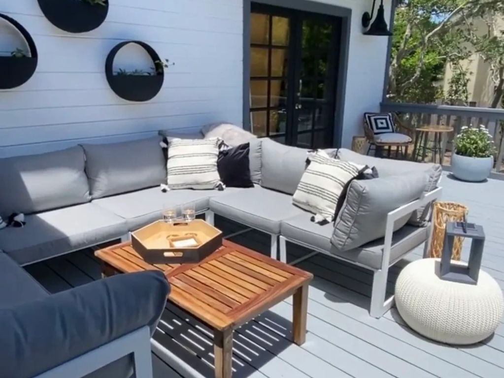 A casual transitional modern deck complete with fire pit and lush greenery.