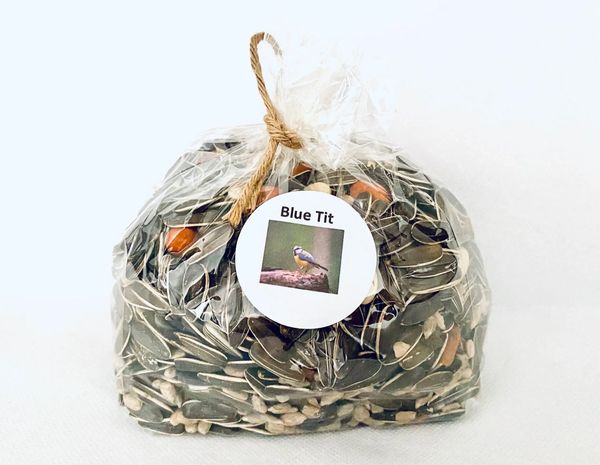 A bag of fresh bird food with juicy sunflower seeds and peanuts.  Recyclable bag tied with twine.