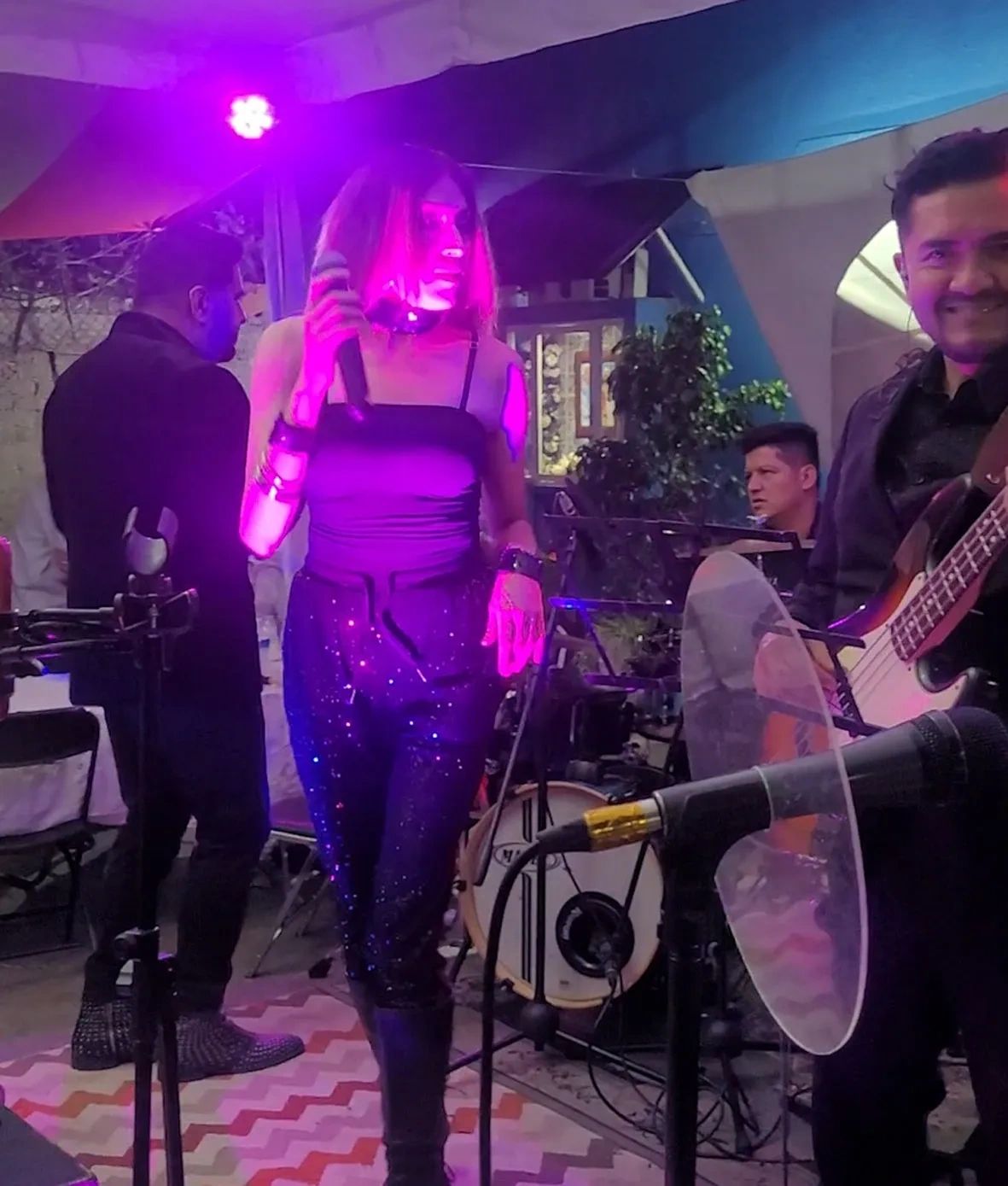 Band performing live with vibrant purple stage lighting.
