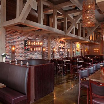 Cozy bar interior with wooden beams and brick walls.