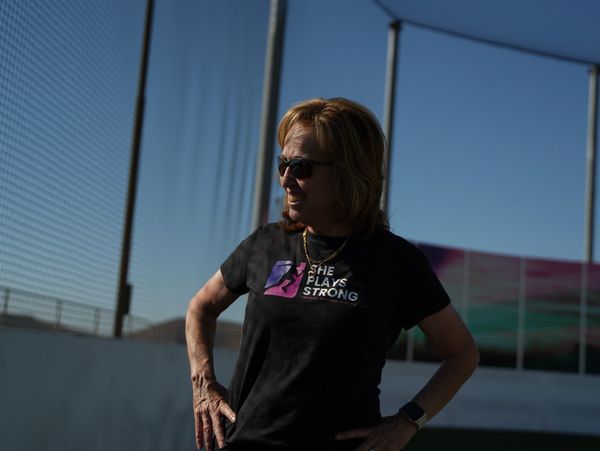 Woman in sunglasses wearing a 'She Plays Strong' shirt.