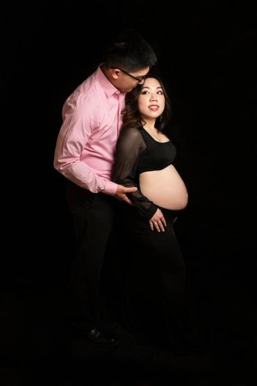 A loving couple embraces, celebrating pregnancy with gentle affection.