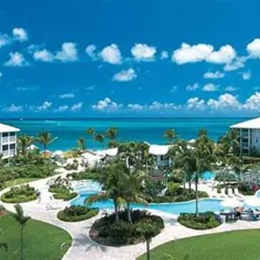 Resort with pool and ocean view on a sunny day.