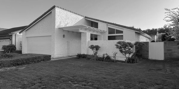 Modern single-story house with a manicured lawn.