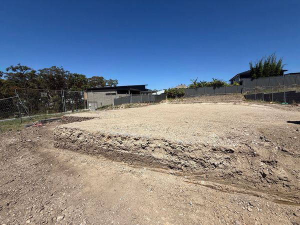 Cleared and leveled construction site under clear blue sky.