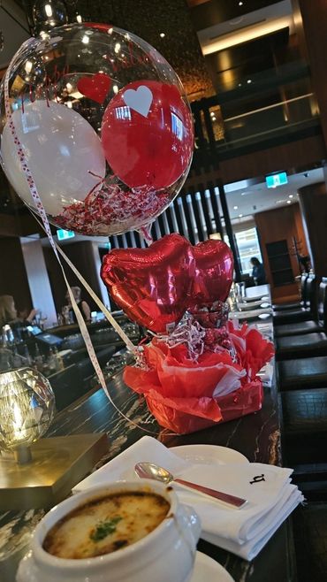 Valentine's themed balloons and a cozy dining setup at a restaurant bar.