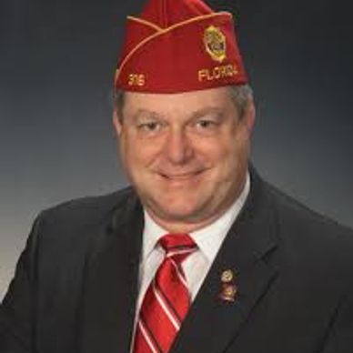 Man in a suit with a red and white striped tie.