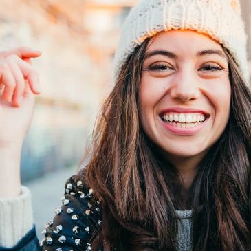 Jeune femme souriante portant un bonnet en hiver.