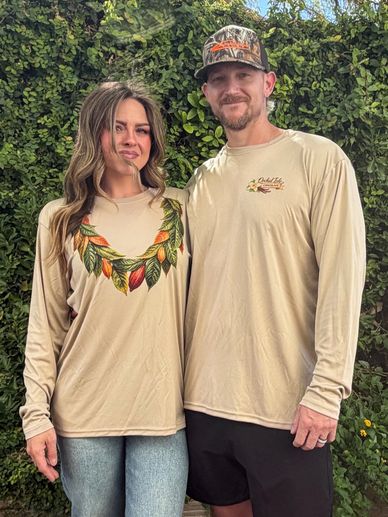 Couple wearing matching beige long-sleeve shirts outdoors.