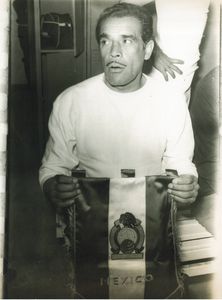 Man holding a damaged Mexican flag, looking concerned.