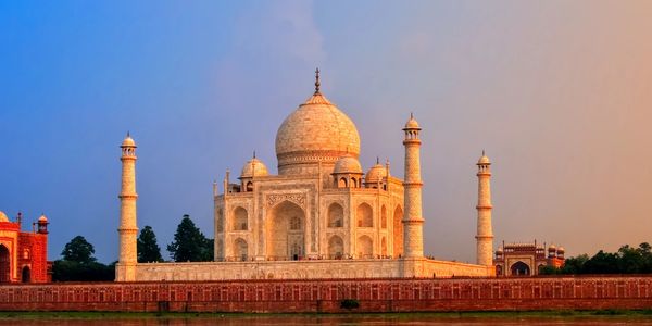 The Taj Mahal reflecting beautifully in the river at sunset.