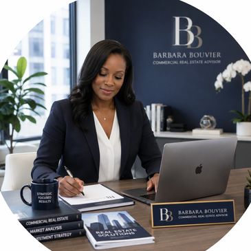 Professional woman working at desk in real estate office.