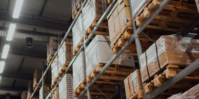 Warehouse shelves stocked with pallets of boxed goods.