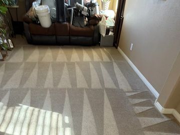 Carpet with a geometric triangle pattern created by vacuum lines in a living room.