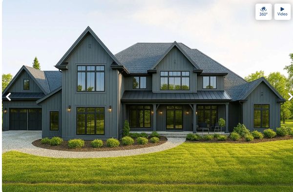 Modern dark gray house with large windows and well-kept lawn.