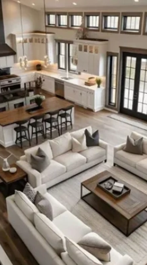 Open-concept living room and kitchen with neutral tones and modern furnishings.