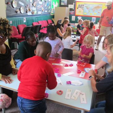Children and adults engaging in a classroom craft activity.