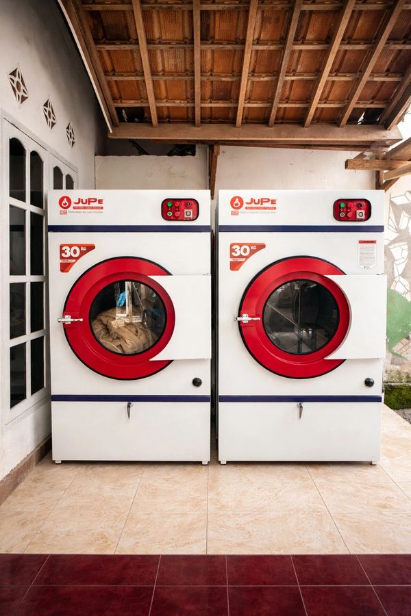 Two white and red JuPe washing machines under a wooden roof.