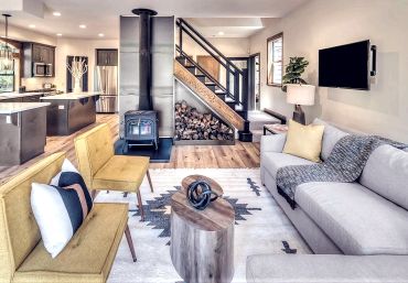 Cozy modern living room with wood stove and stylish furniture.
