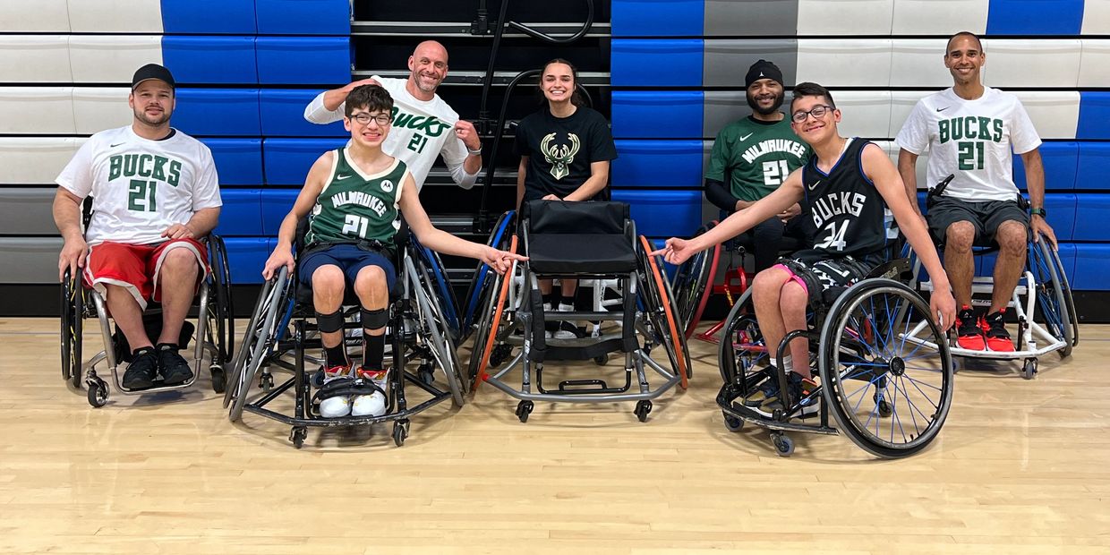 Group photo of wheelchair basketball players and supporters.