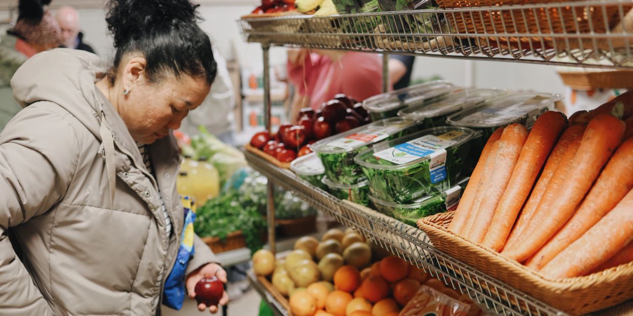 Woman shopping for vegetables in a grocery store.