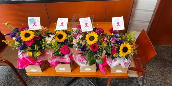 Four colorful floral arrangements in boxes on a table.
